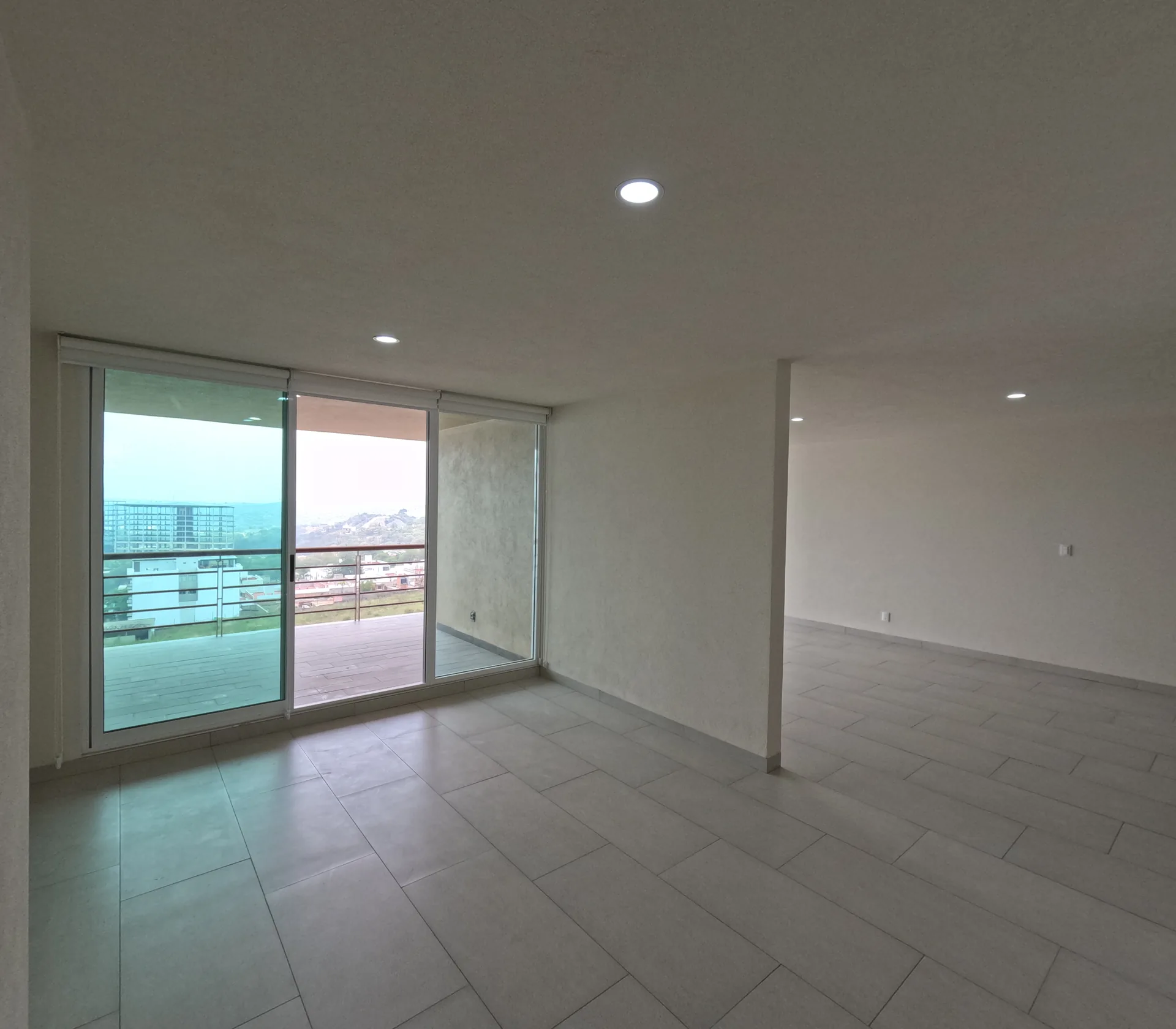 Sala de departamento con balcon amplio y vista a la montana de Jilotzingo.